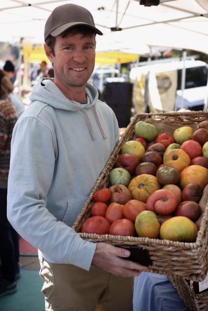 a person standing in front of a fruit stand