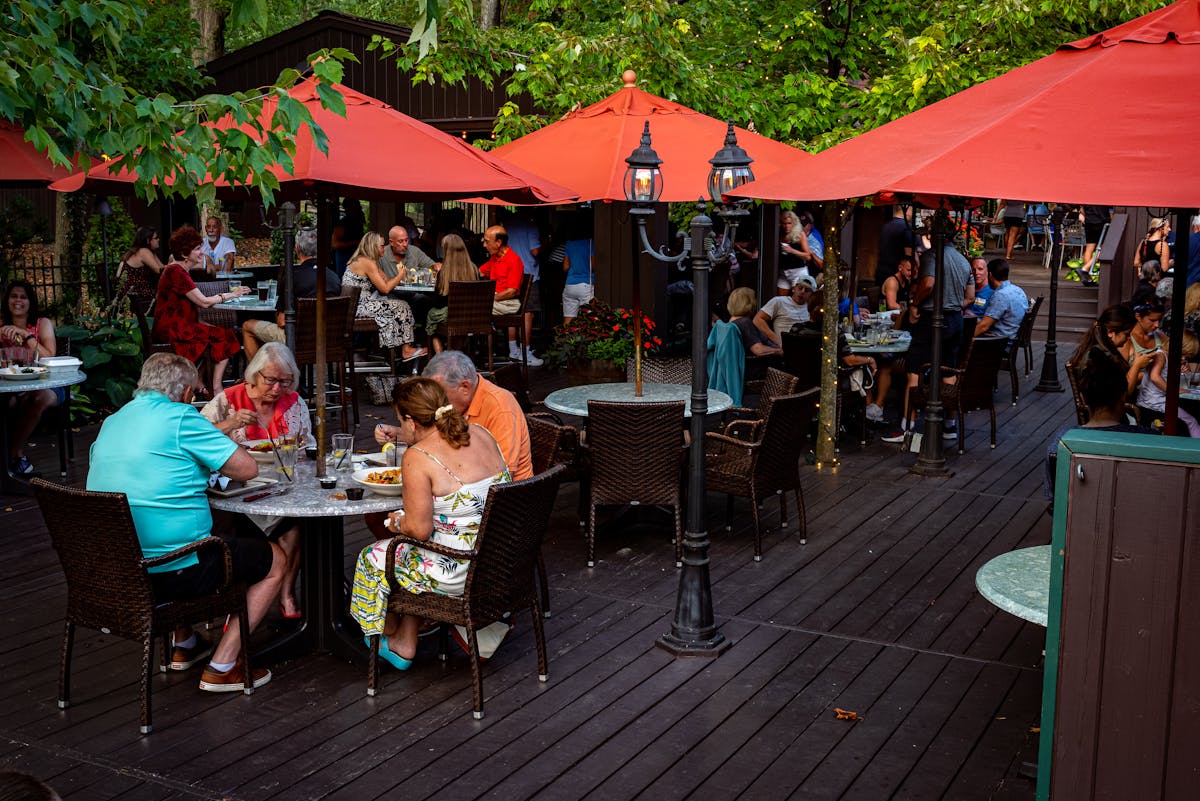people dining at an outdoor patio with umbrellas