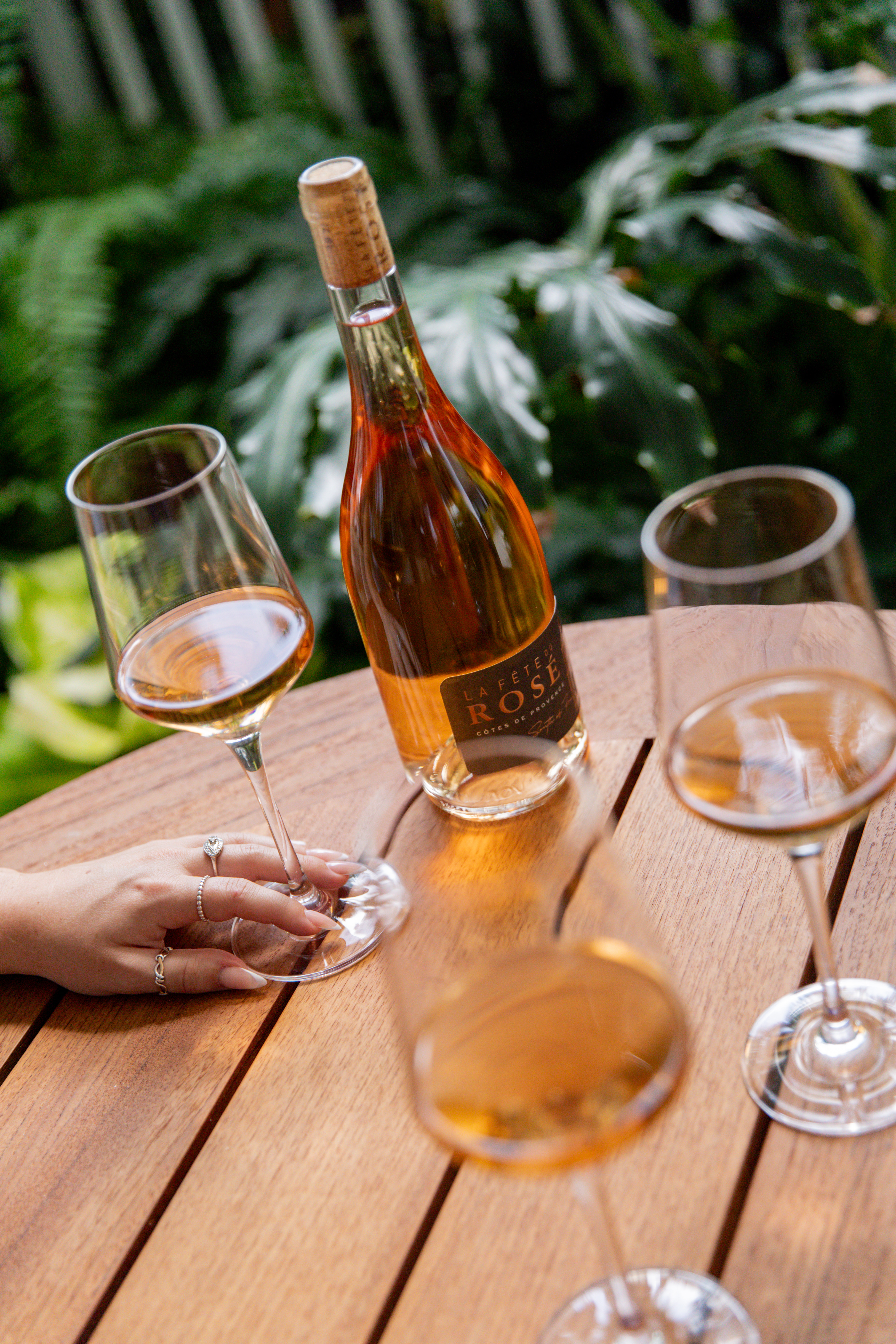 a glass of wine sitting on top of a wooden table