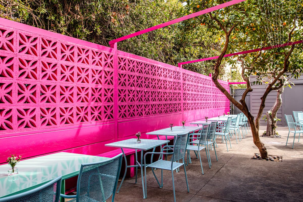 restaurant patio with pink wall and blue tables