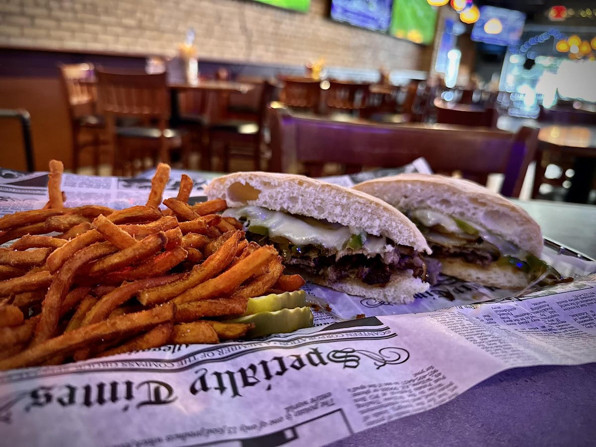 a close up of a sandwich and fries on a table