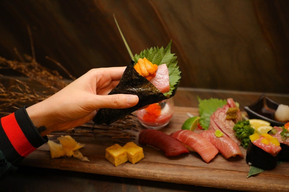 a hand holding a piece of food on a table