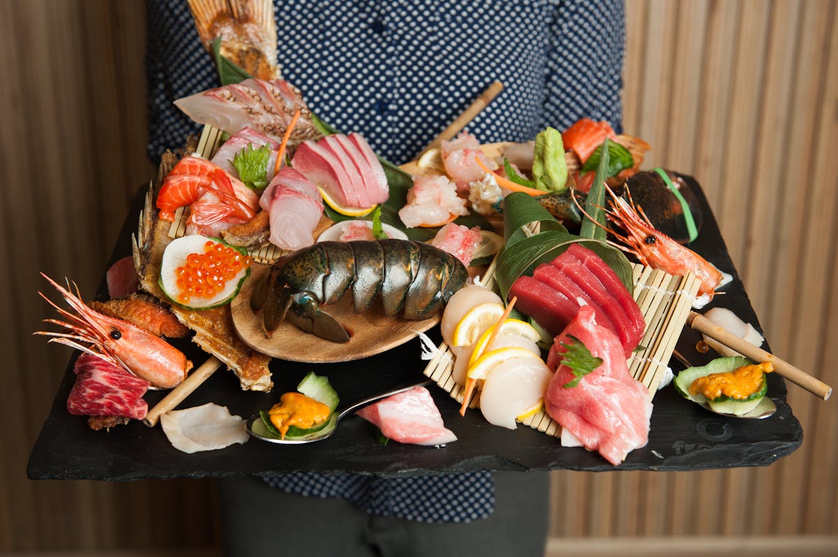 Server showcasing a full platter of sashimi