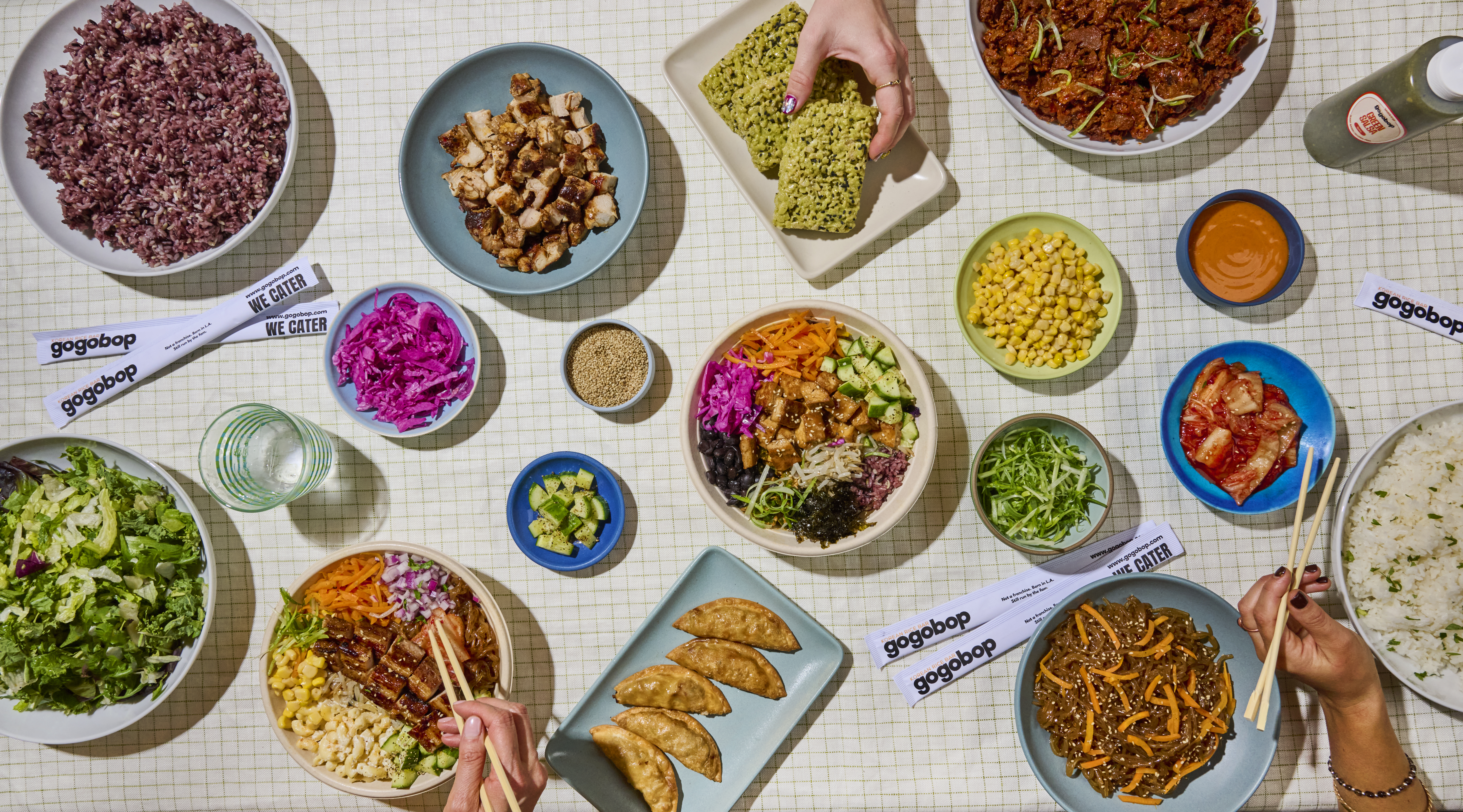 various plates of rice, vegetables, meats, and desserts on a table