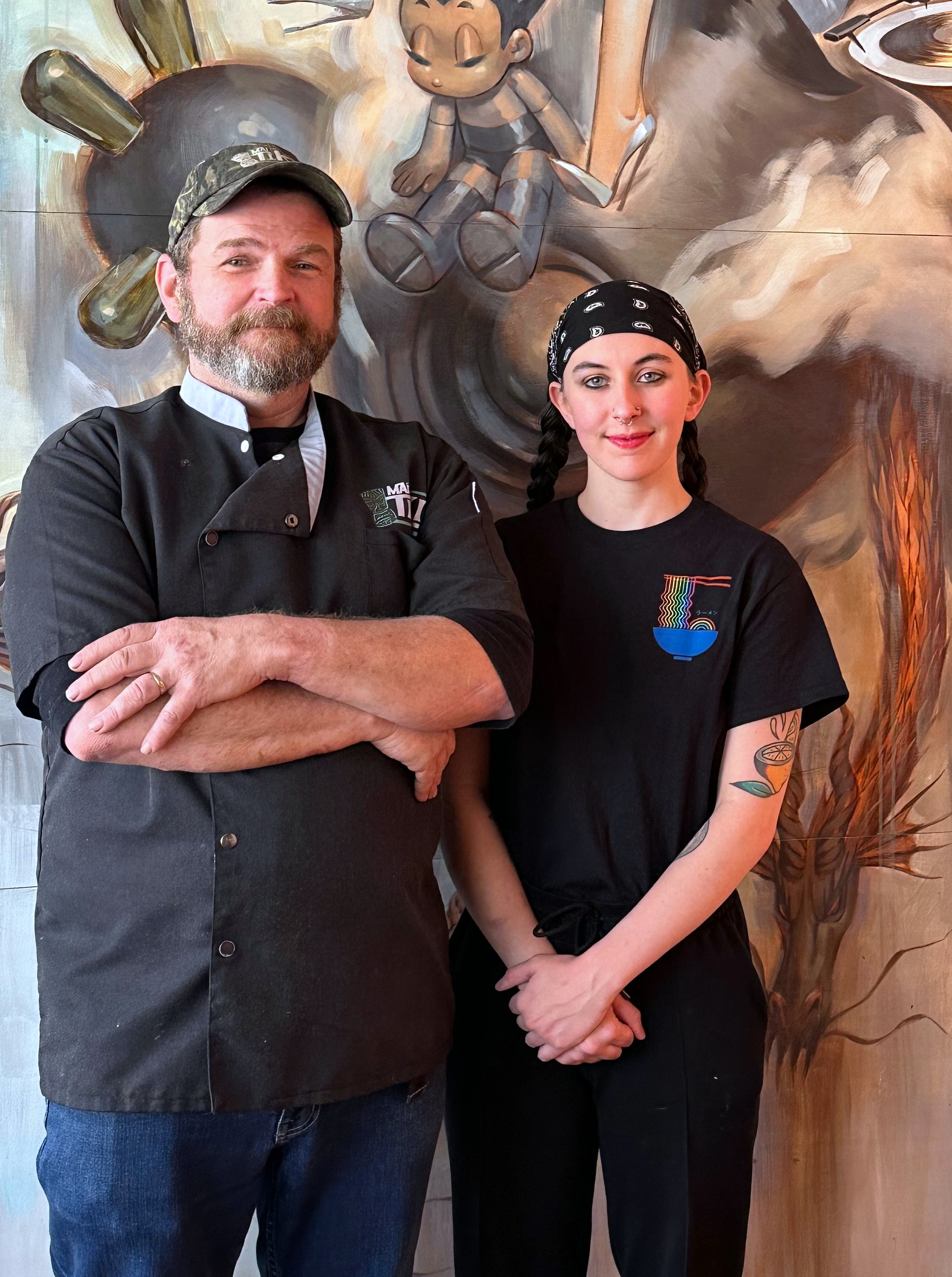 a man and woman standing in front of a painting