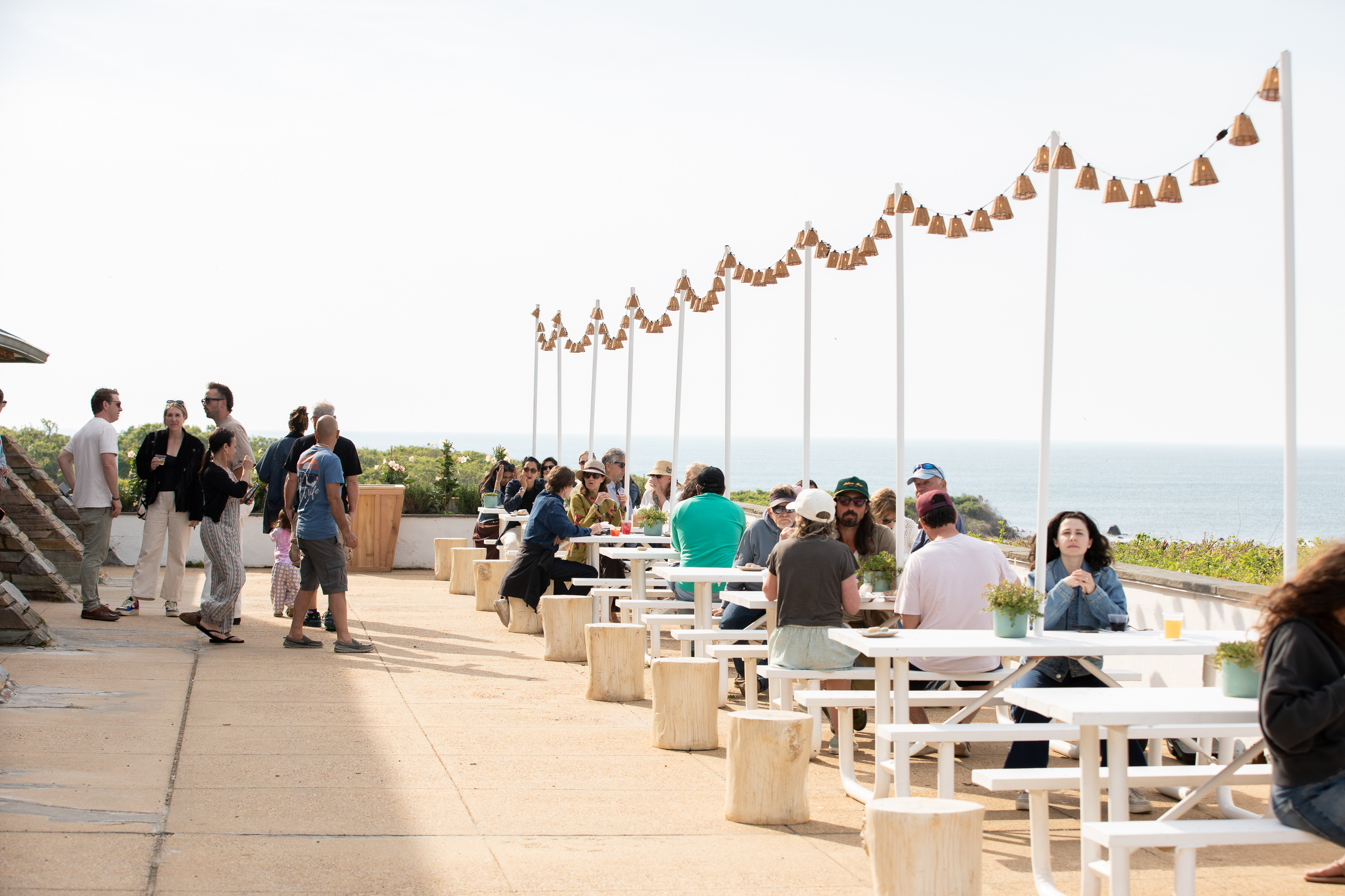a group of people sitting at tables outside