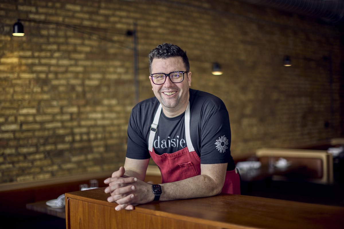 a man sitting on top of a wooden table