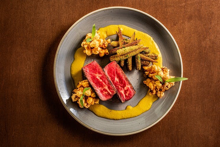 a plate full of food sitting on top of a wooden table