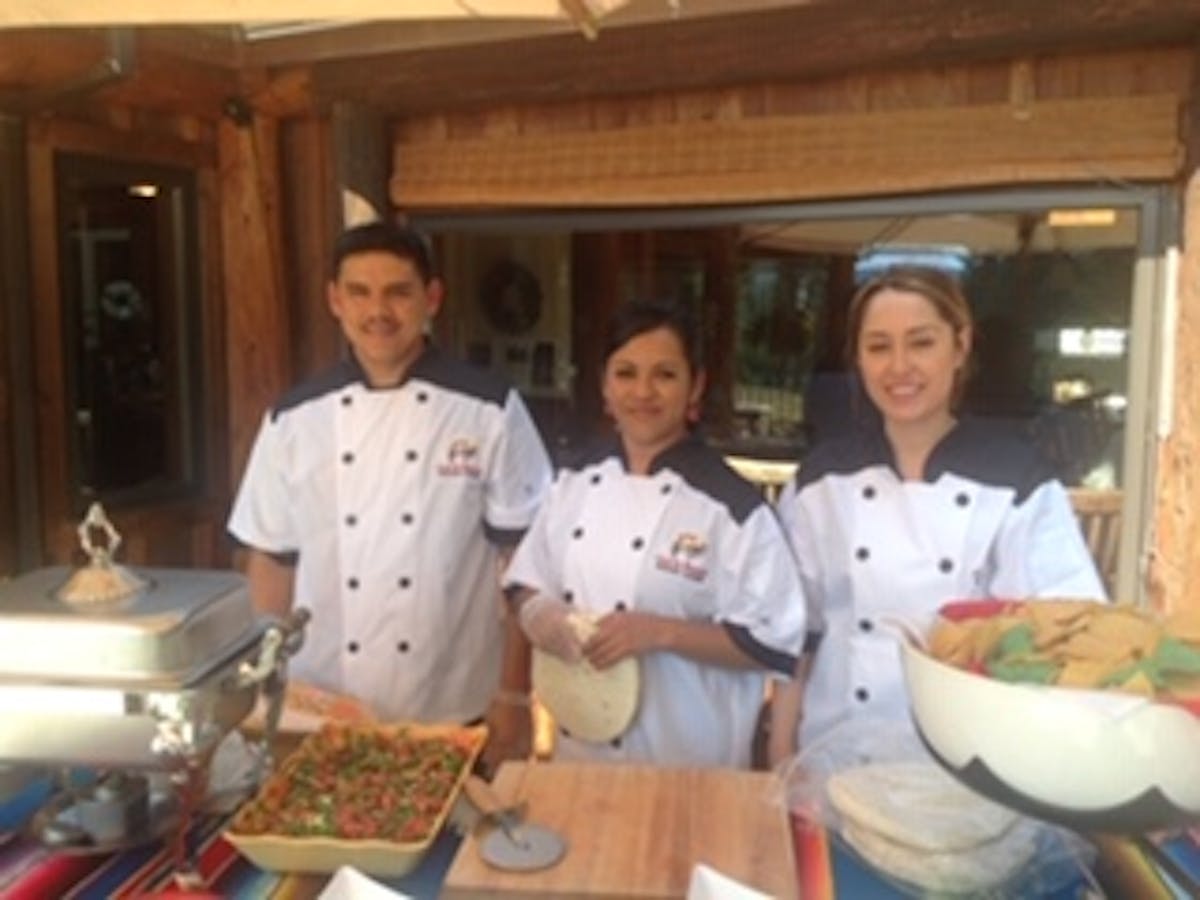 a group of people preparing food in a kitchen