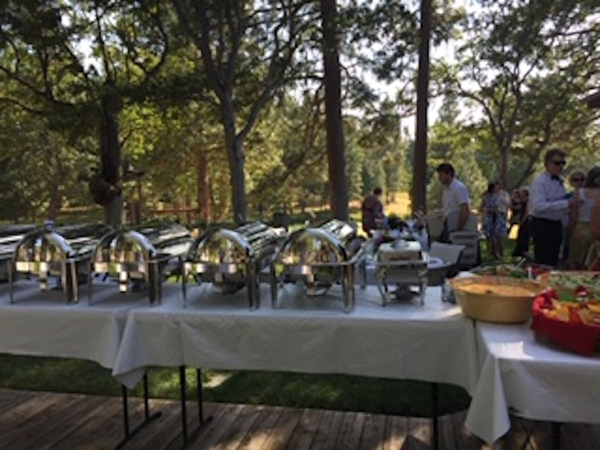 a group of people sitting at a table in a park