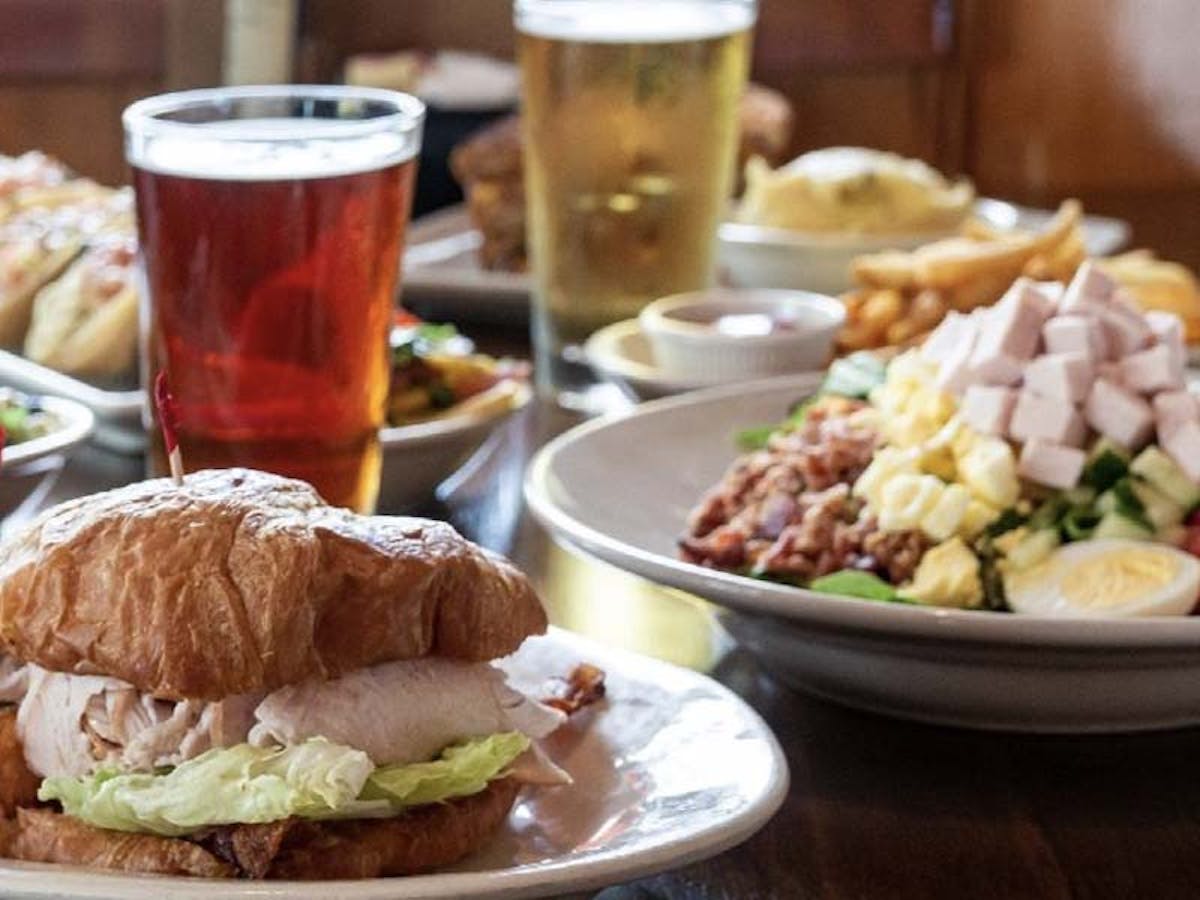 a plate of food with a sandwich and a cup of beer