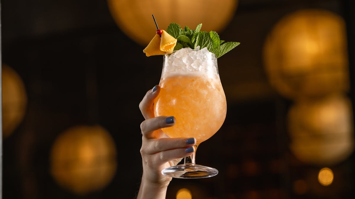 a person holding a glass of orange juice