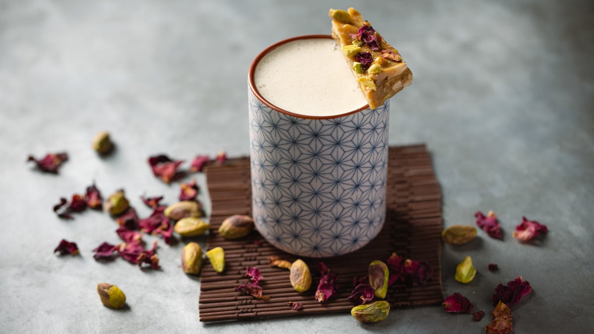 a piece of cake on a plate next to a cup of coffee