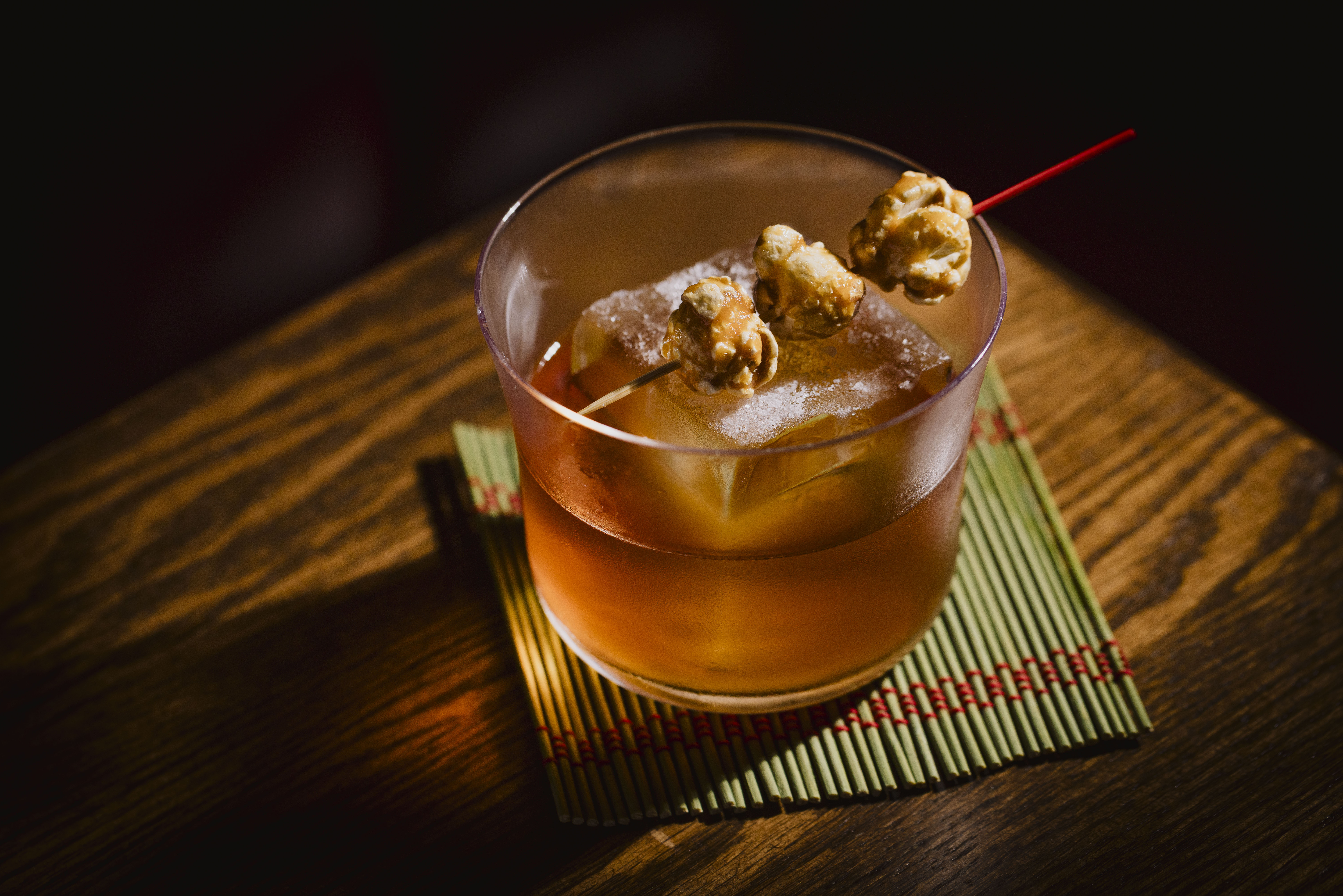 a drink with ice cubes and popcorn on it