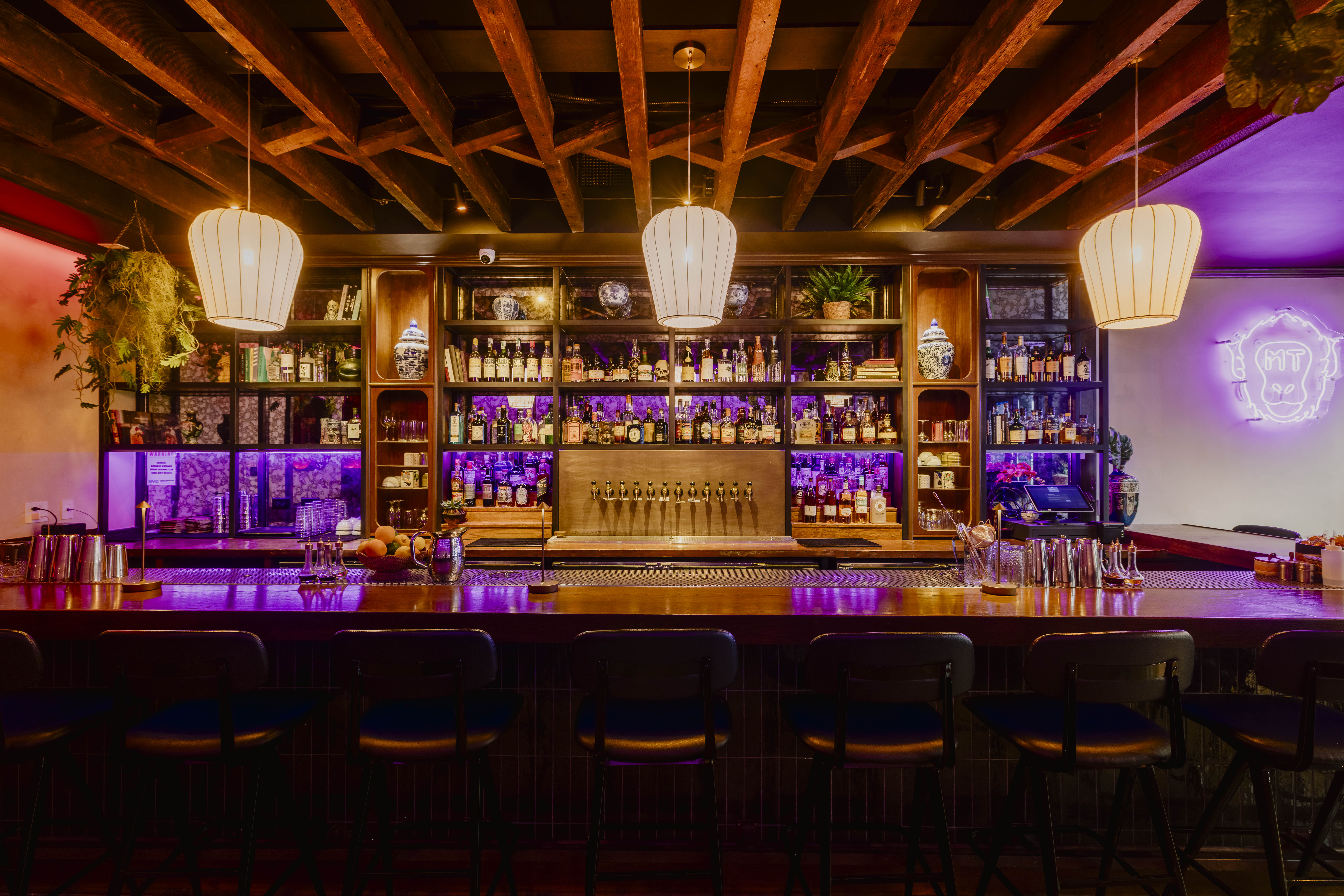 a bar with a row of chairs and a bar with lights