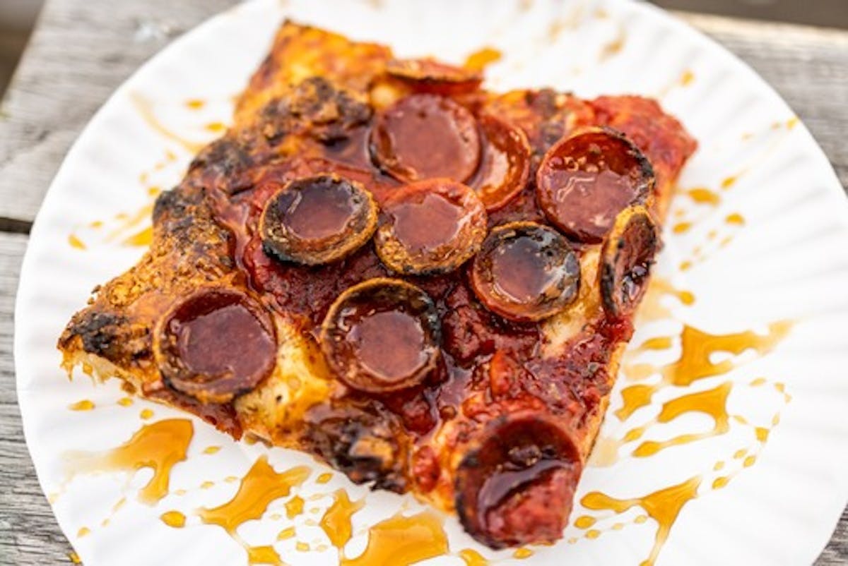 a slice of pizza on a paper plate