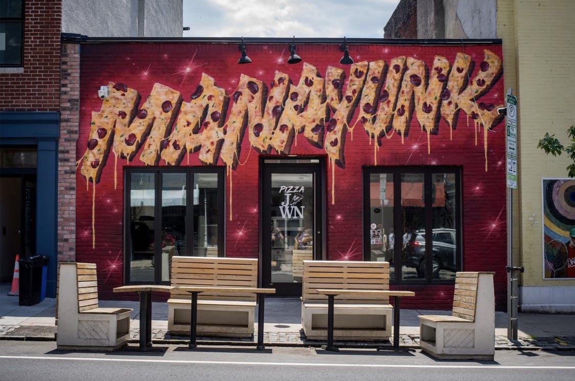 a person sitting on a bench in front of a store