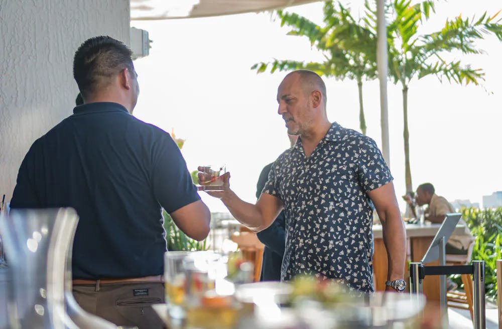 a couple of people standing around a table