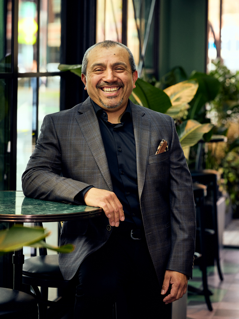 a man in a suit leaning on a table