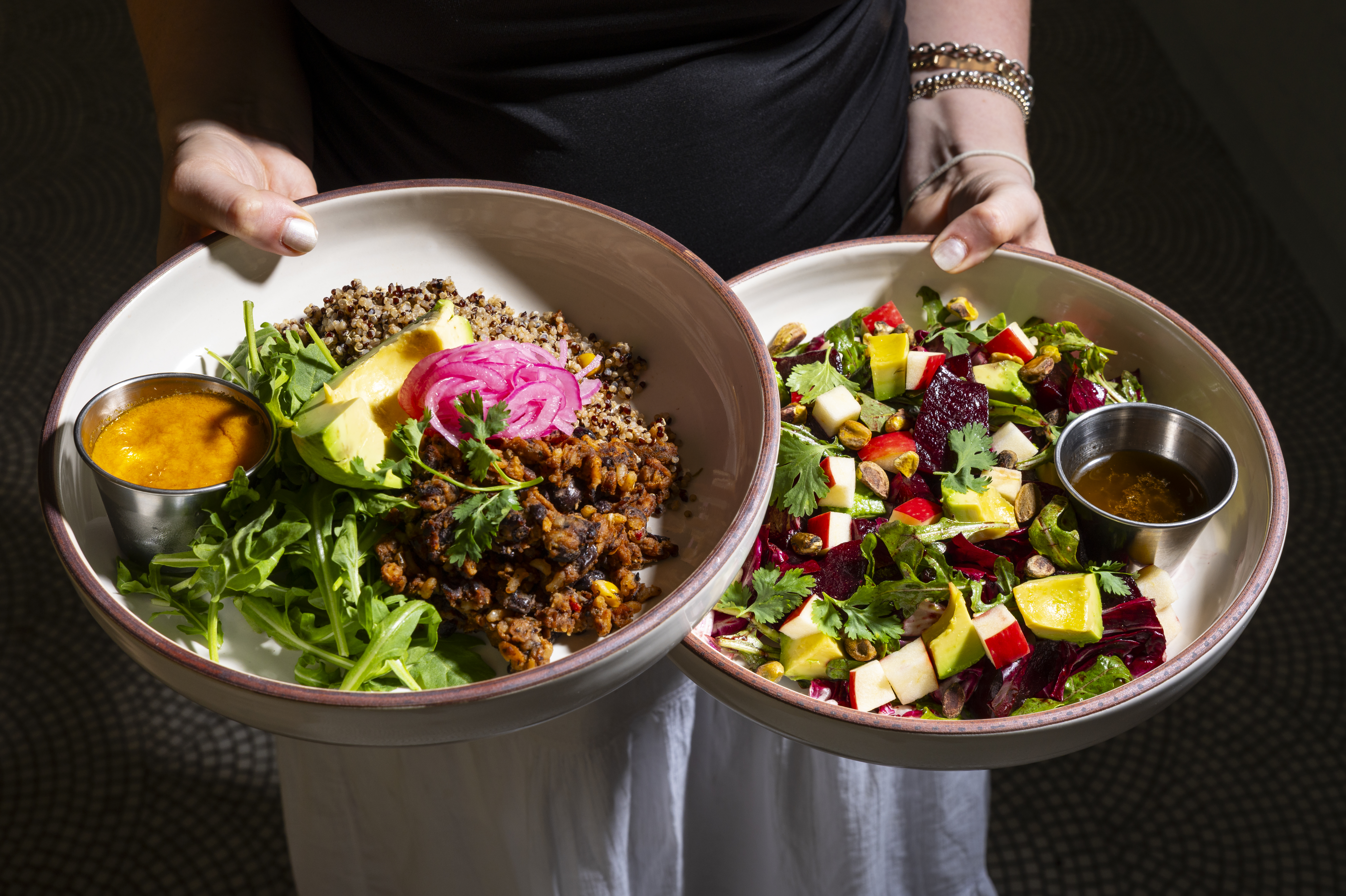 a woman holding a bowl of salad