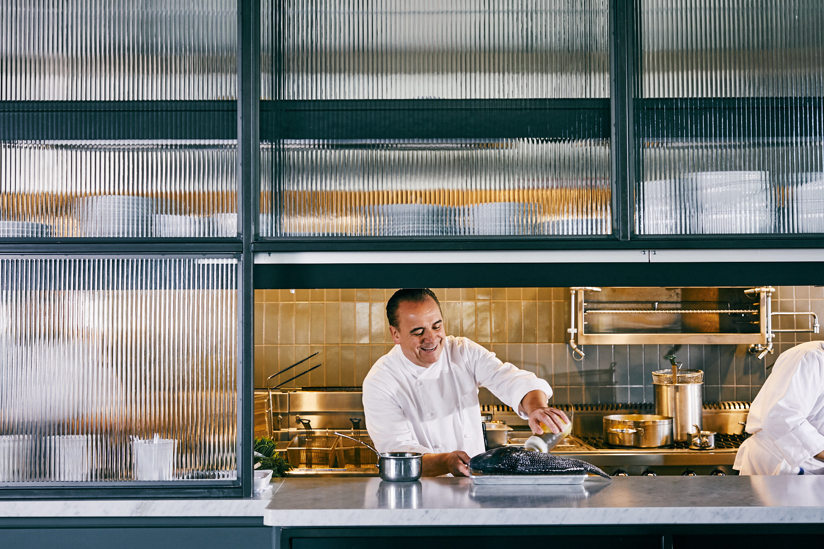 a man standing in a kitchen preparing food