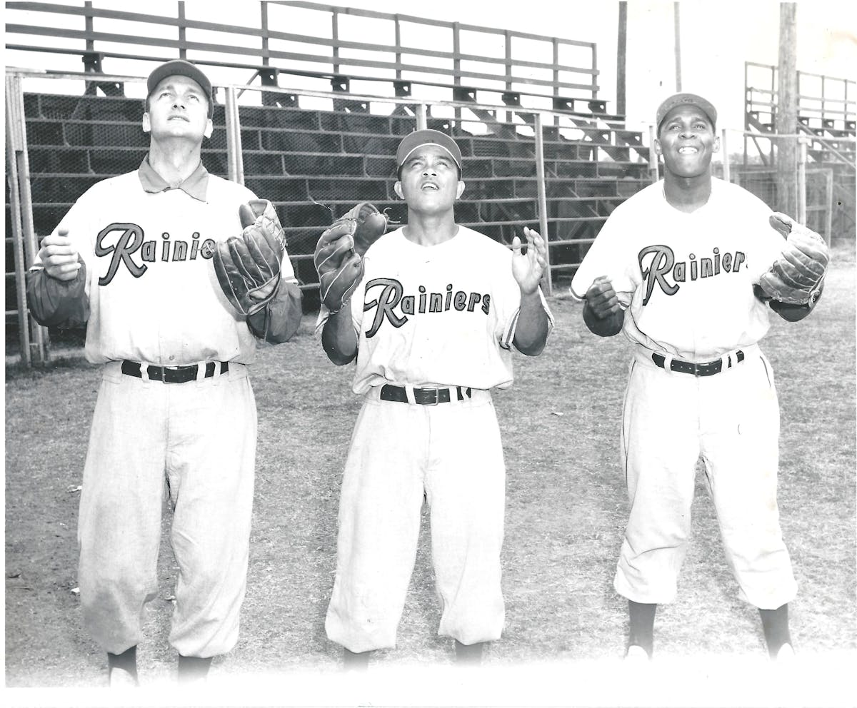 a group of baseball players standing on a field posing for the camera
