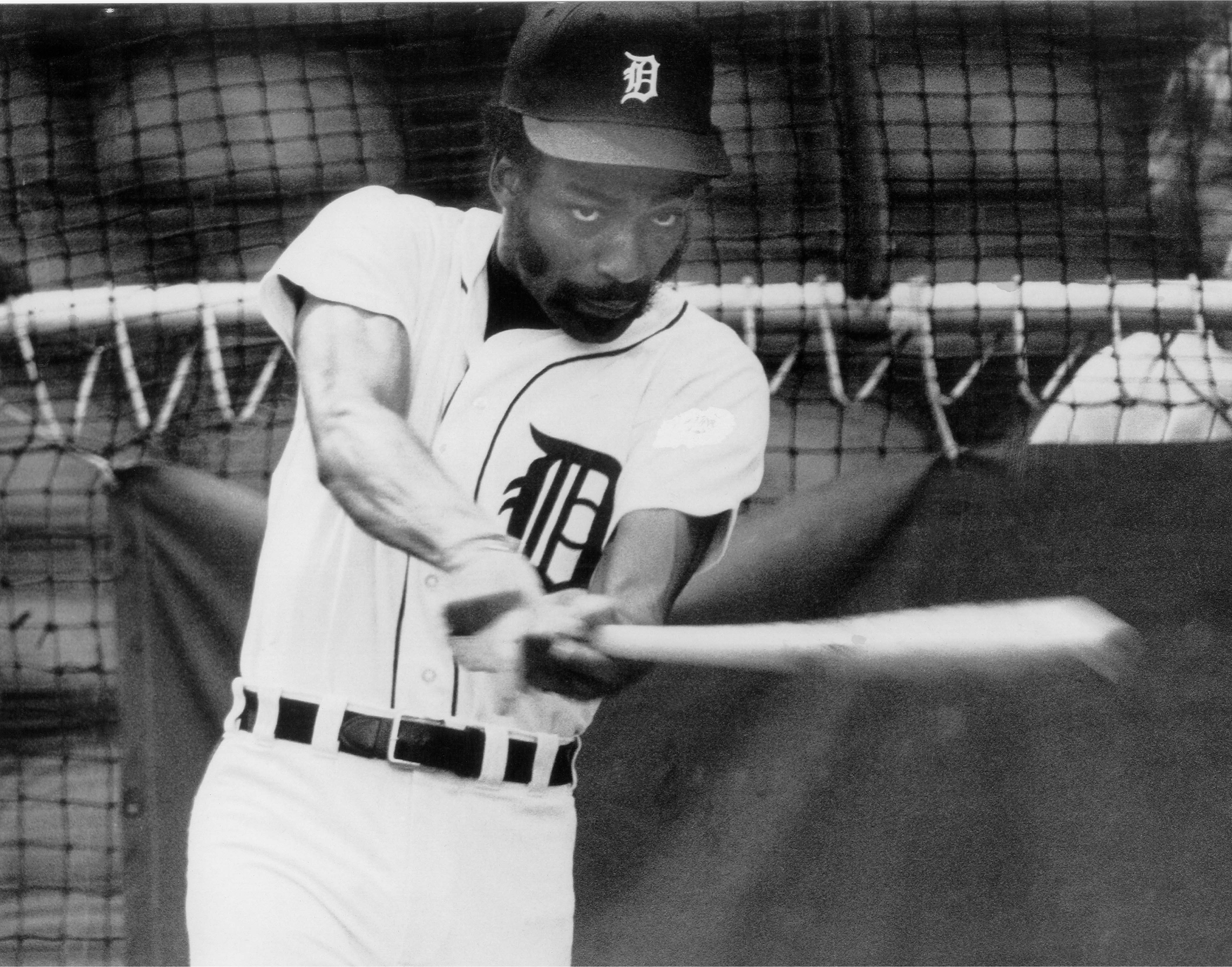 a baseball player holding a racket