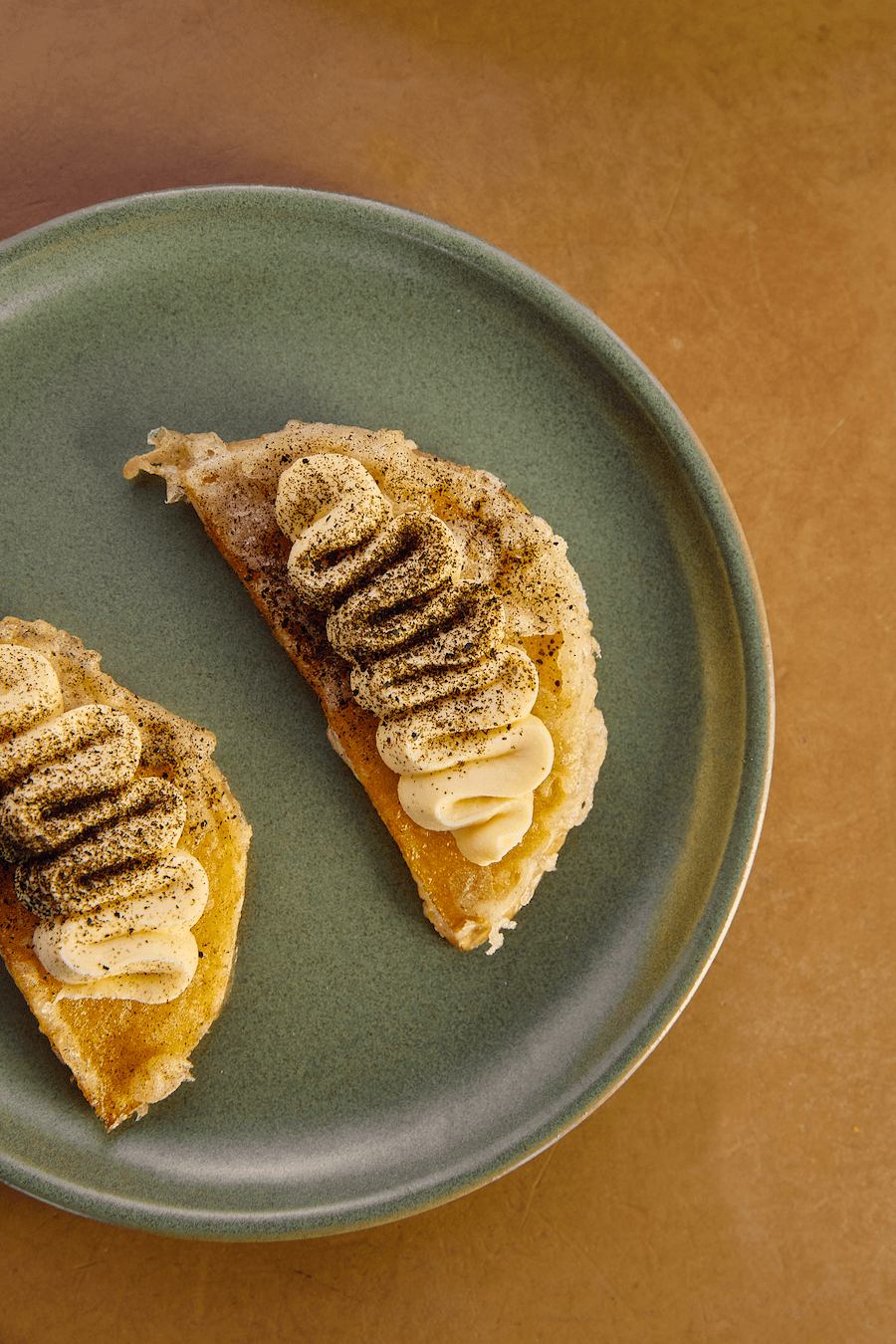 A plate with a fancy crescent shaped dessert