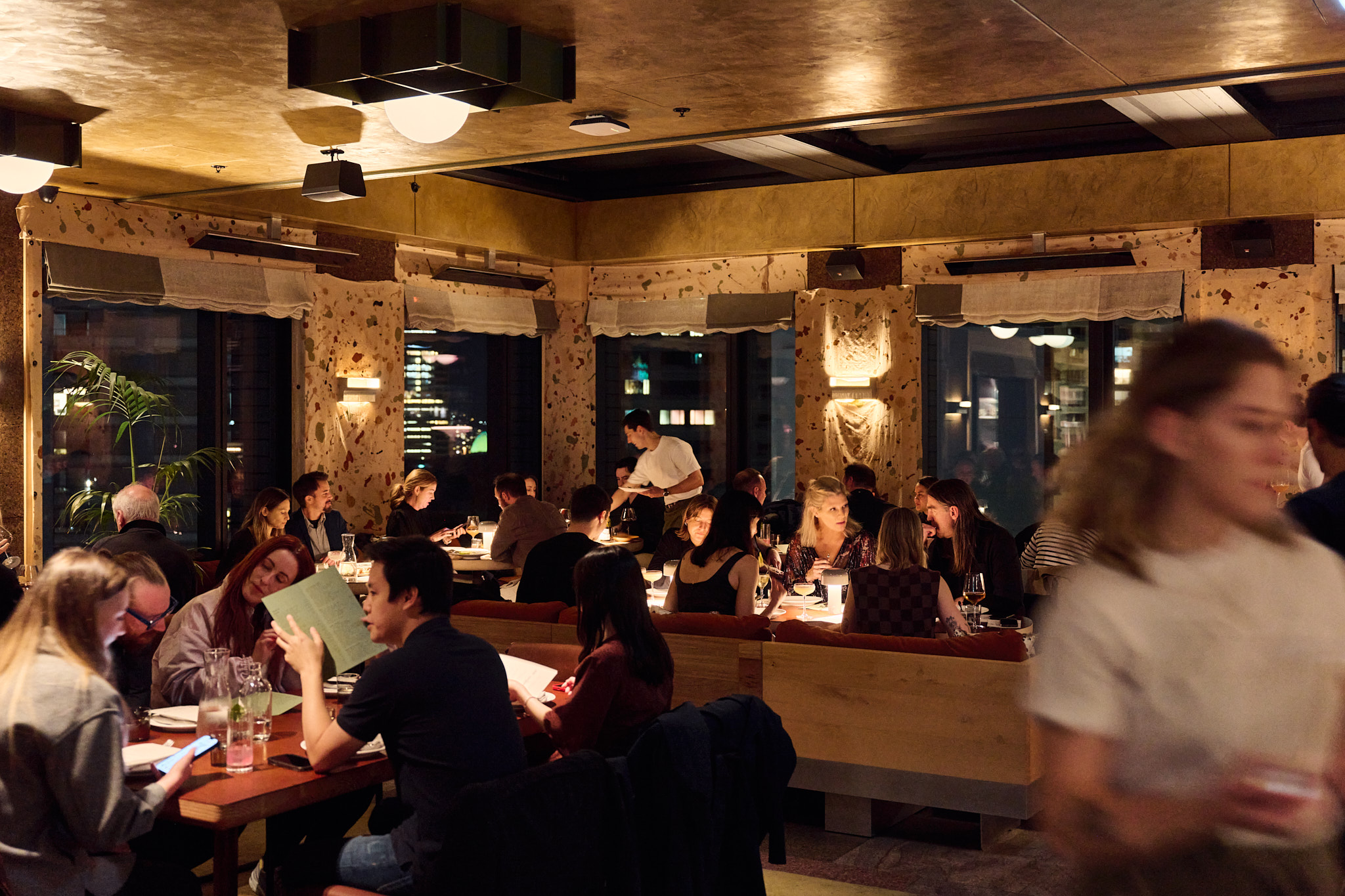 a group of people sitting at tables in a restaurant