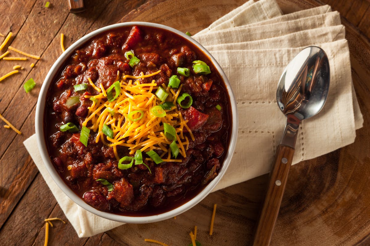 a bowl of food sitting on top of a wooden table