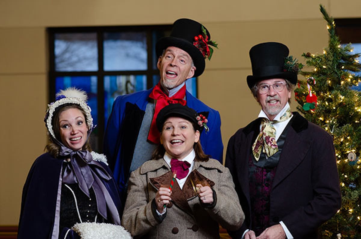 a group of people standing next to a person in a suit and tie