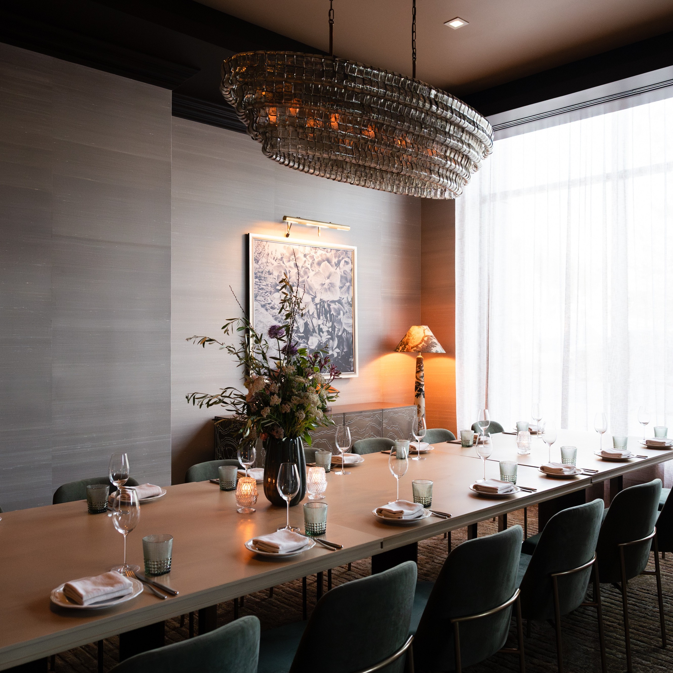 a long table with chairs and a chandelier