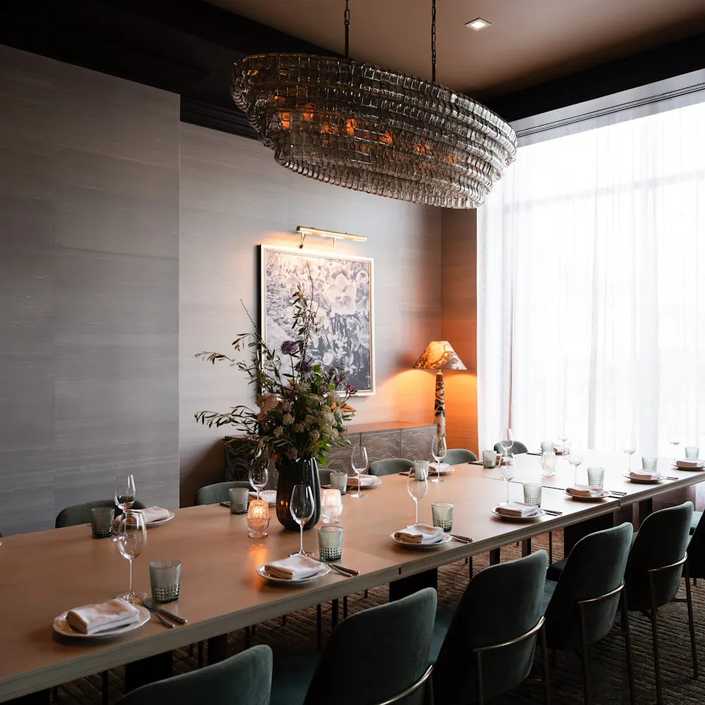 a long table with chairs and a chandelier