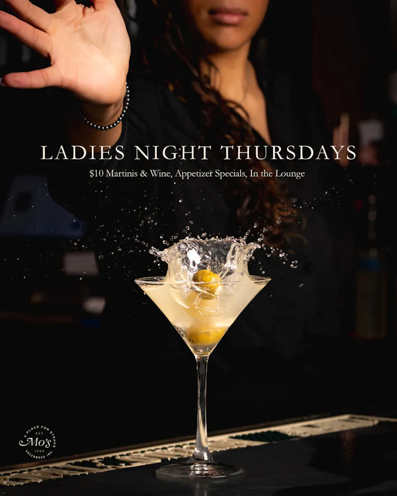 a woman reaching out to a martini glass with a splash of liquid