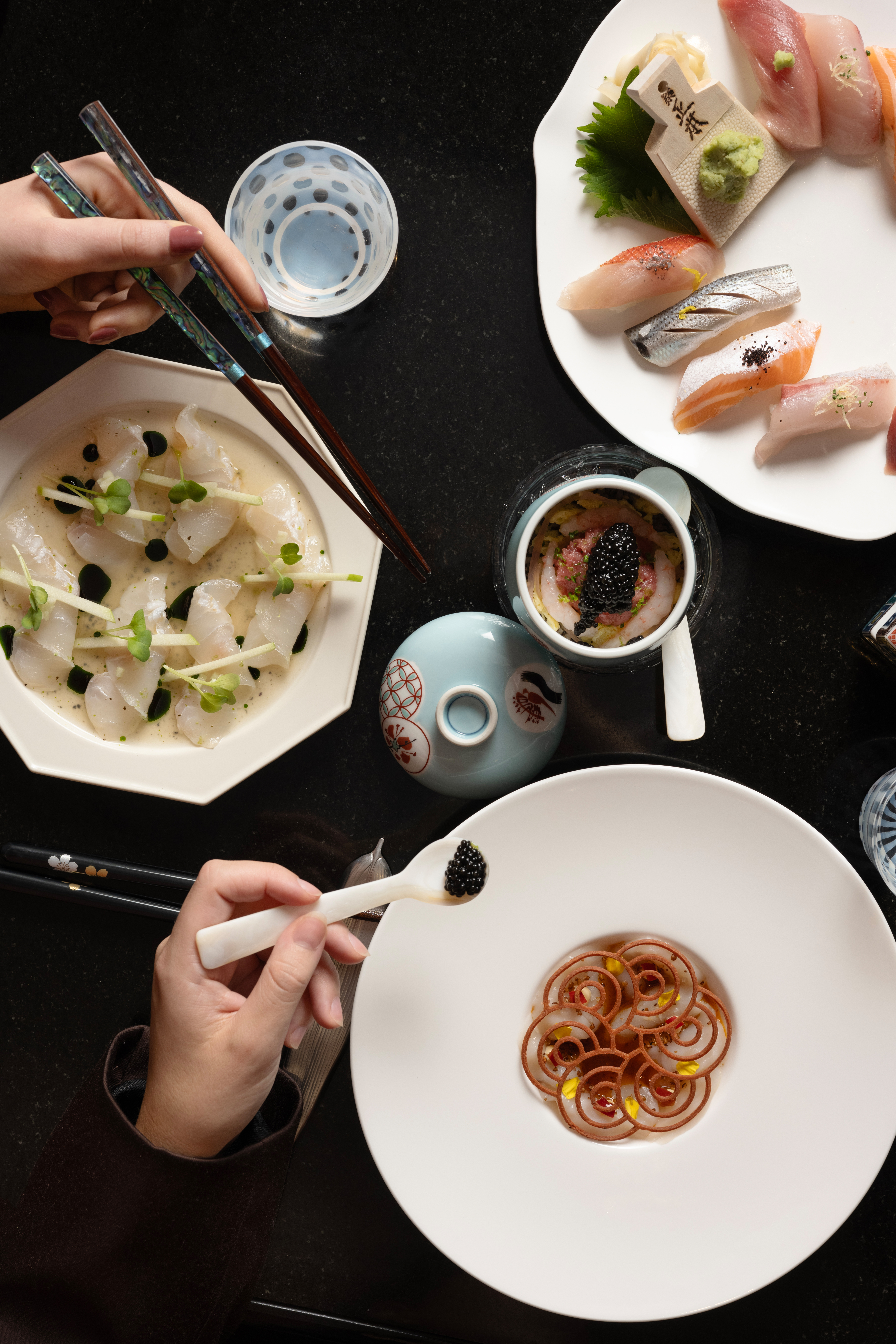 a table with plates of food and chopsticks