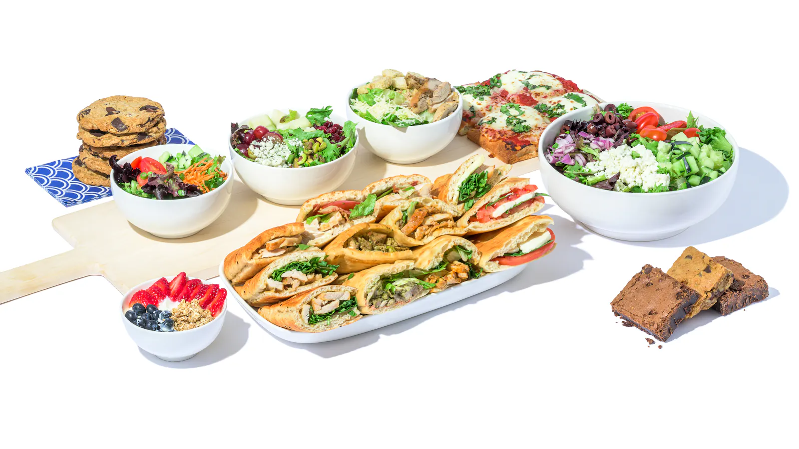 A Cosi catering spread of platters, salads and sandwiches