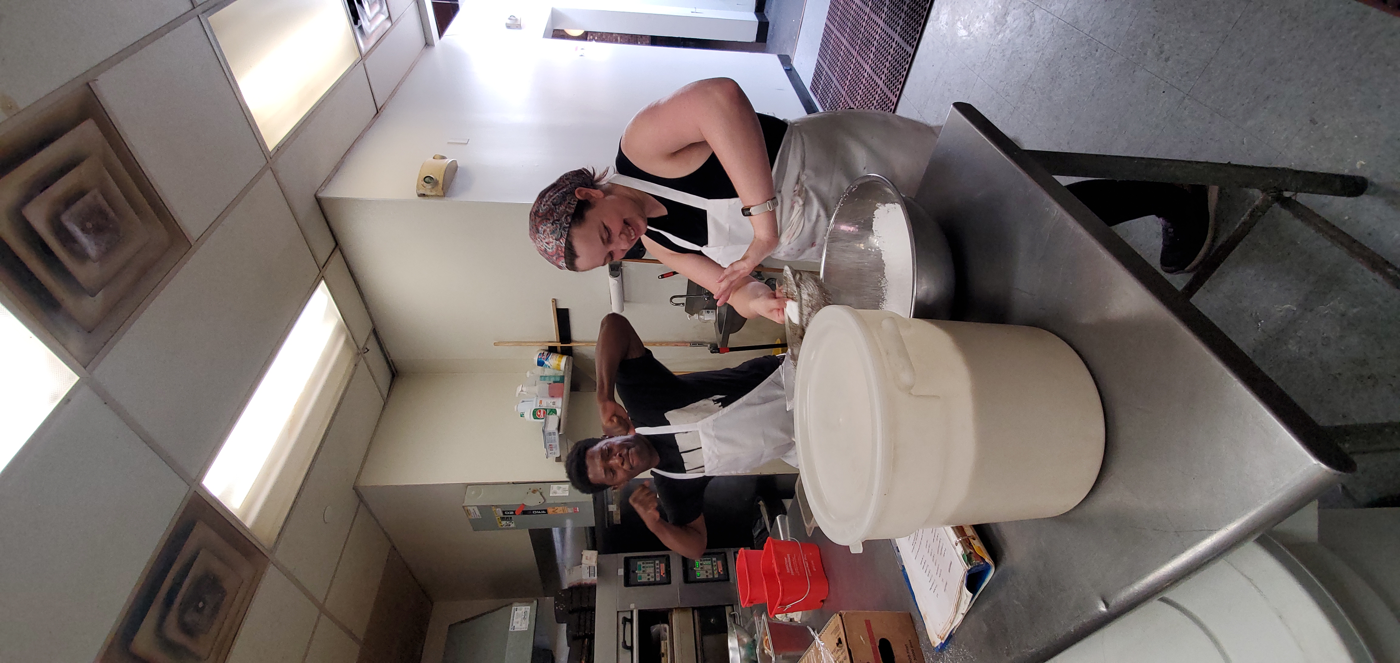 a man and woman preparing food in a kitchen