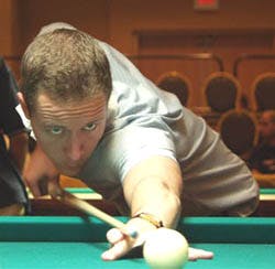 a man sitting at a table with a blue ball