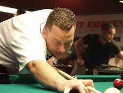 a man sitting at a table with a ball in a room