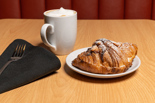 a cup of coffee sitting on top of a wooden table