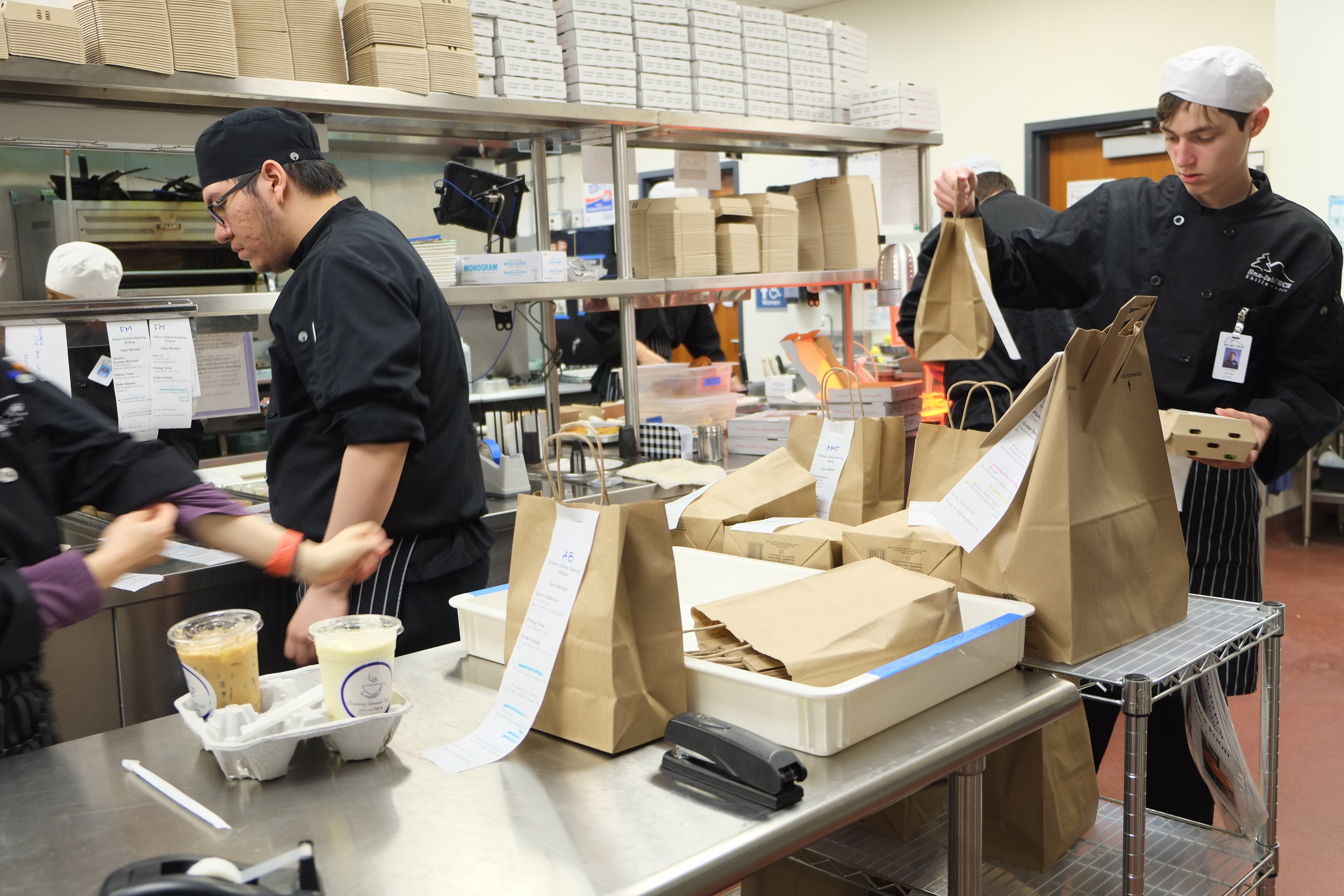 a group of people standing in a kitchen preparing food