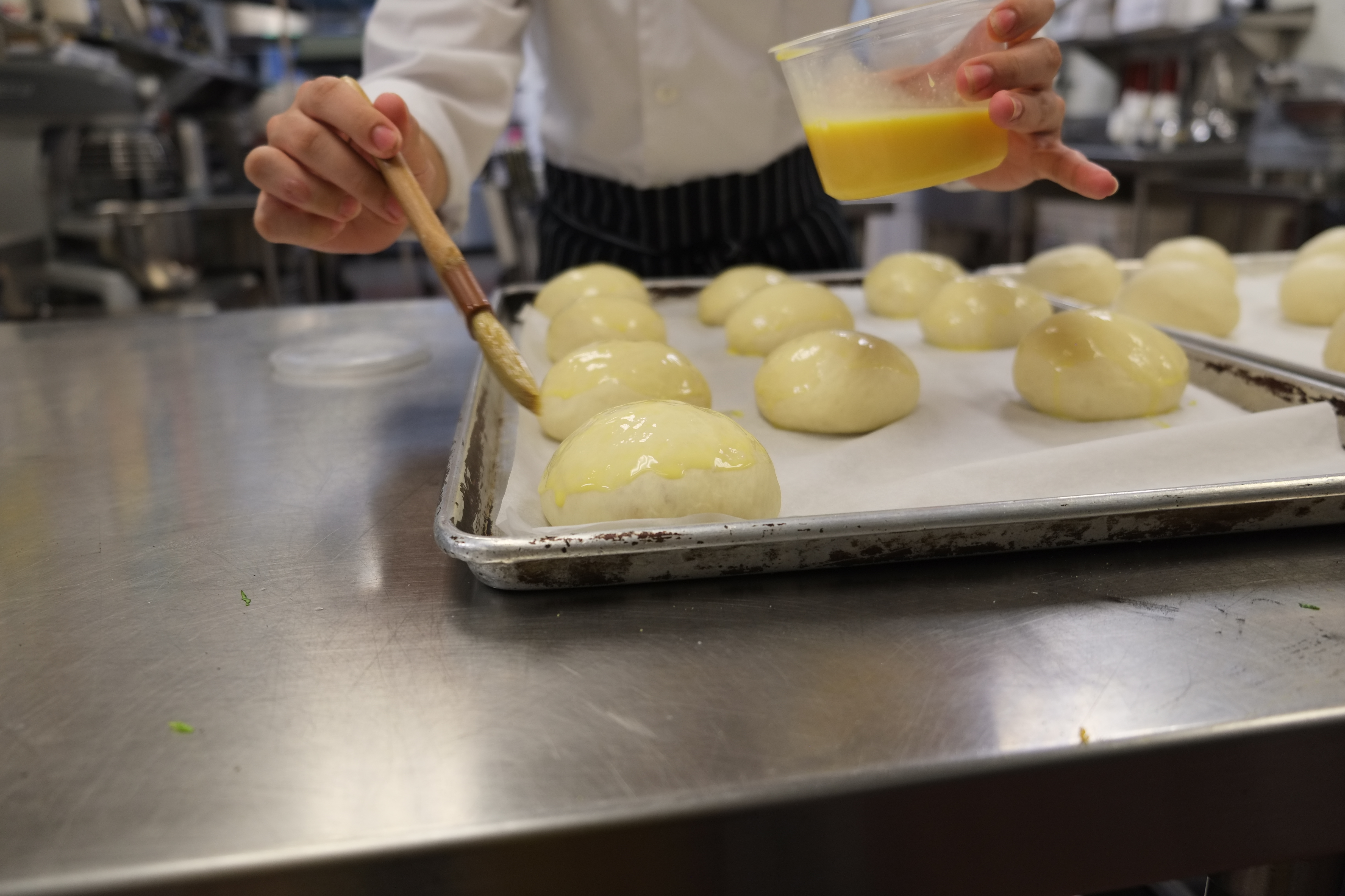 a person holding a pan of food on a table