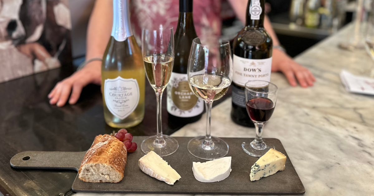 a person sitting at a table with wine glasses