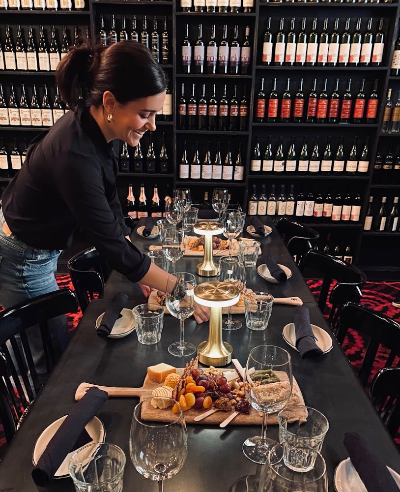 a person sitting at a table with wine glasses