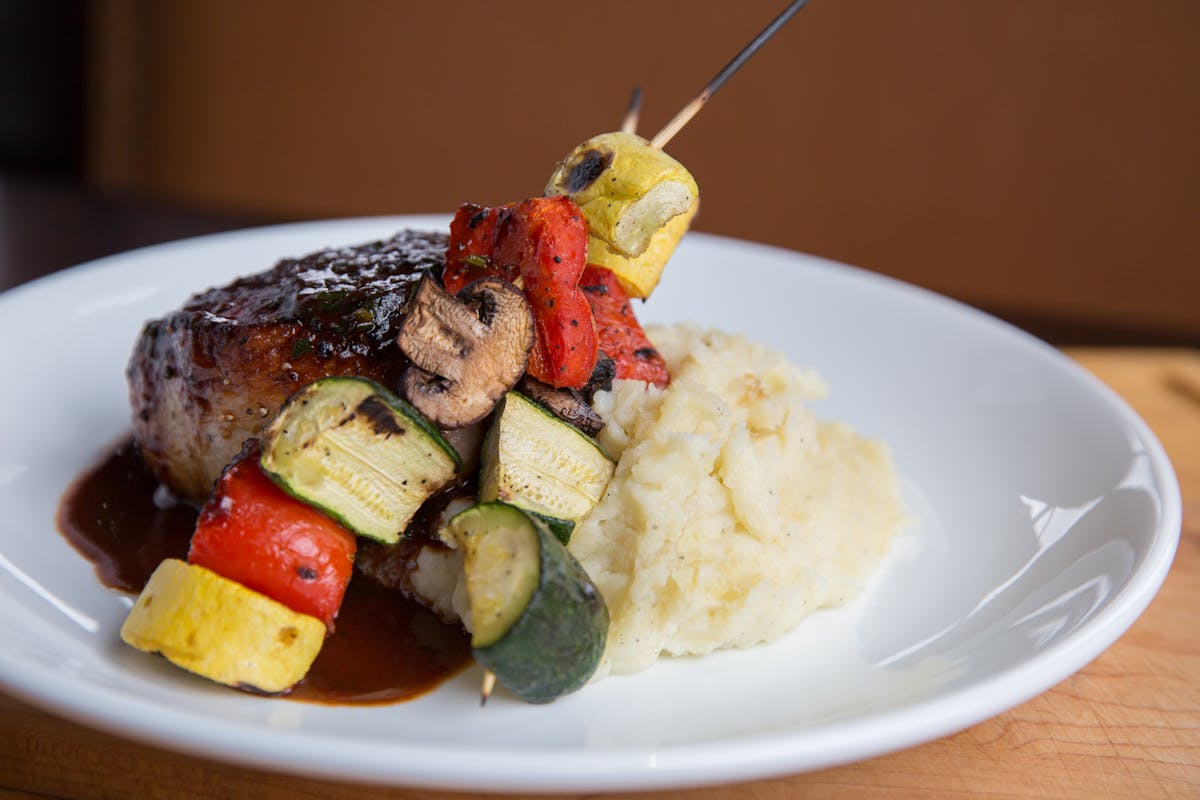 a white plate topped with meat and vegetables