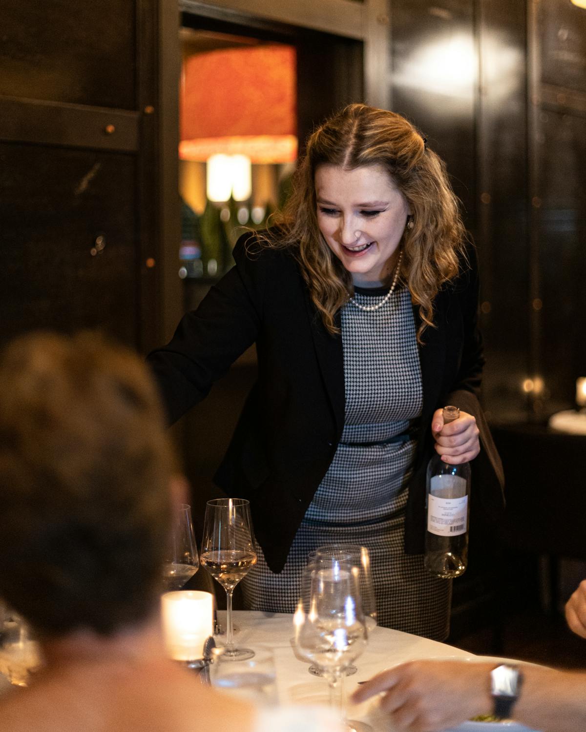 a person sitting at a table with wine glasses