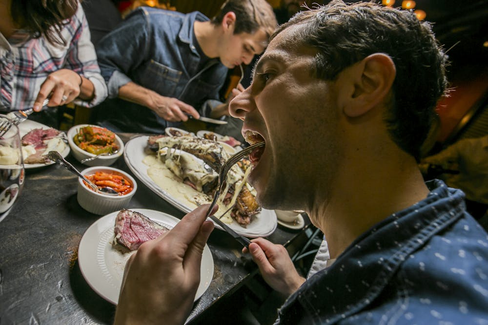 a group of people sitting at a table eating food