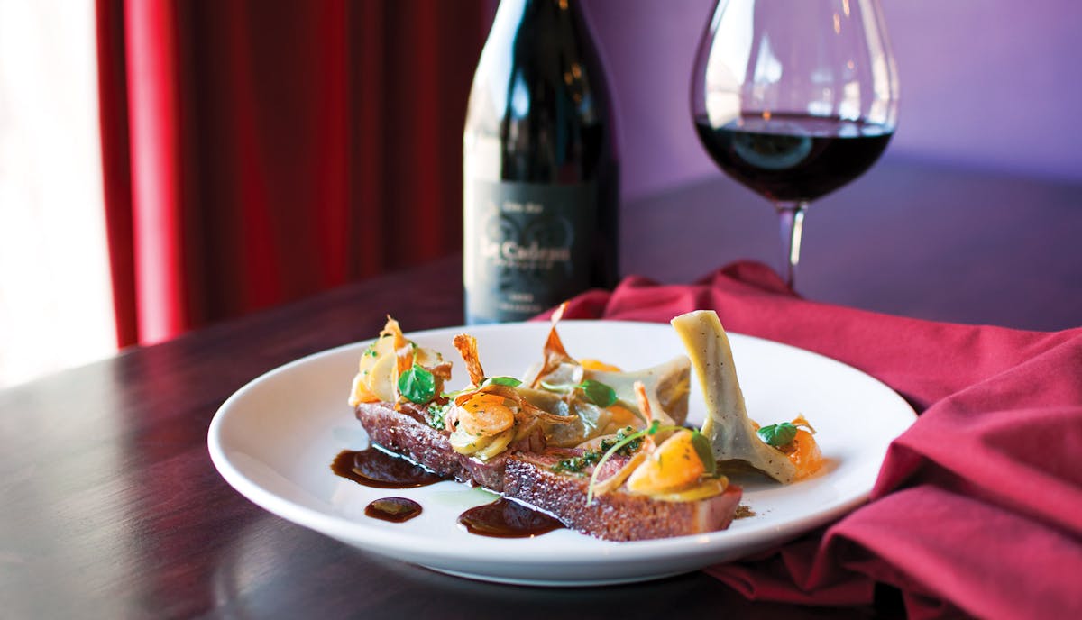 close up of beef steak, wine bottle and a glass