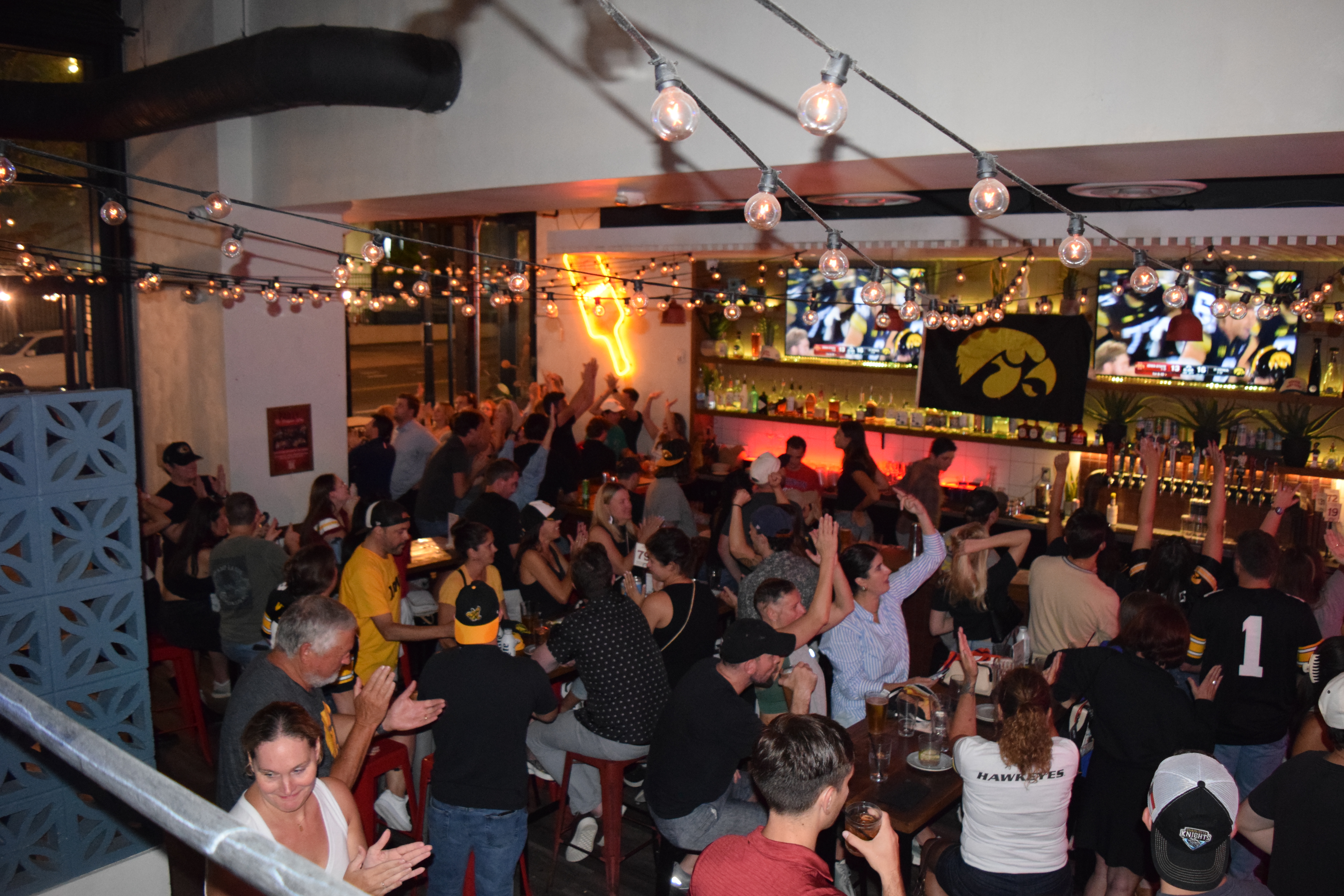 a group of people sitting at tables in a bar