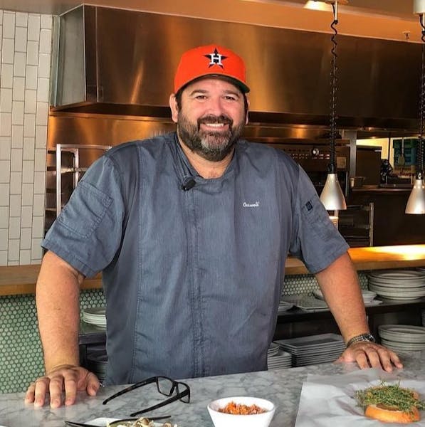 a man standing in a kitchen preparing food
